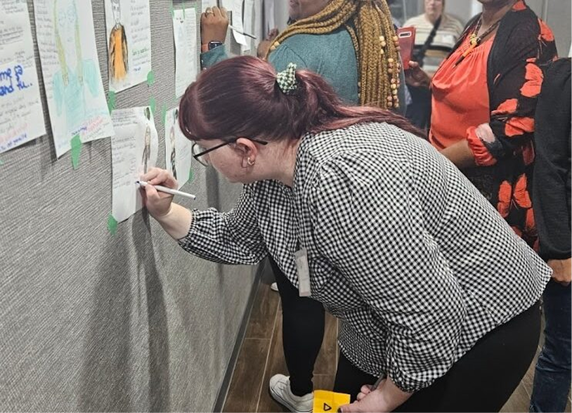 Mélanie écrit au tableau pendant un atelier